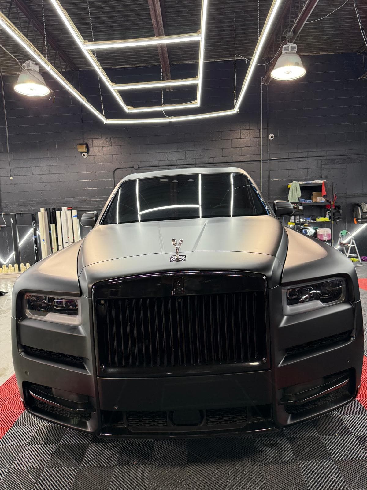 Satin black Rolls-Royce Cullinan head-on, showing its blacked-out grille and Spirit of Ecstasy